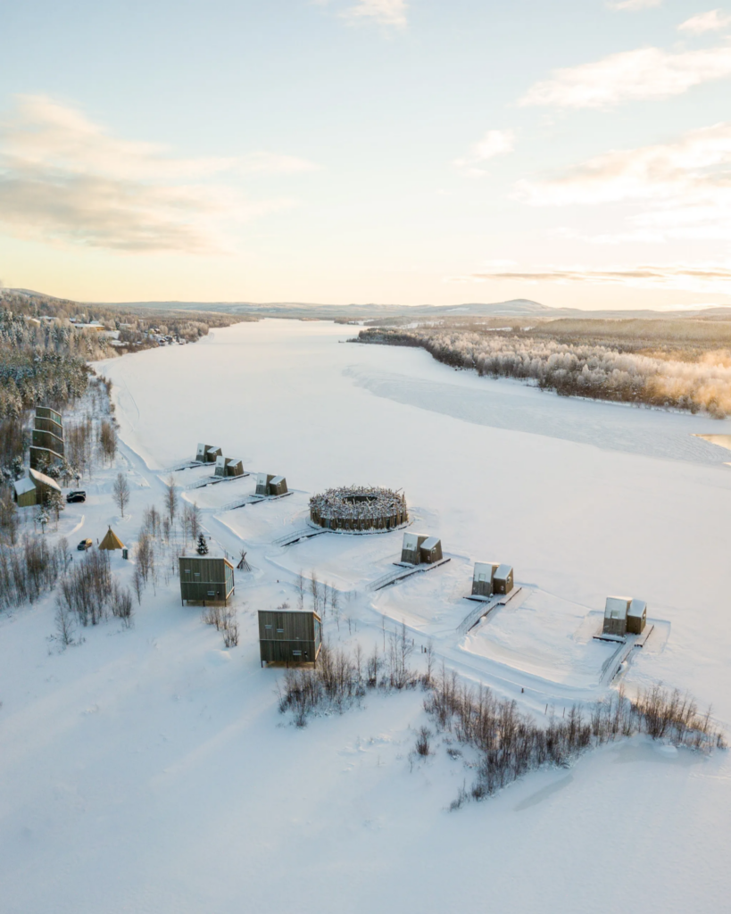 Aerial view of Arctic Bath’s round spa and cabins on the frozen Lule River in Sweden